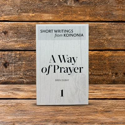 Front cover of A Way of Prayer, featuring a book displayed upright against a rustic wooden background.