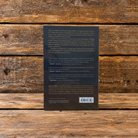 Back cover of The Cotton Patch Evidence by Dallas Lee, featuring a description of Koinonia Farm's history and the book's barcode, displayed against a rustic wooden plank background.