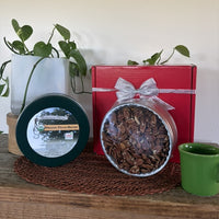 Organic Pecan Halves Gift Tin from Koinonia Farm, shown open and closed beside a red gift box with a silver ribbon.