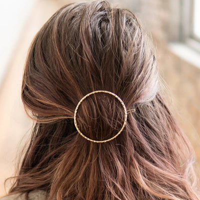 Oversized open circle brass barrette by Fair Anita, styled in hair