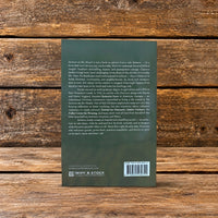 Back cover of Sermon on the Mount by Clarence Jordan, showing the book description and author biography against a rustic wooden background.