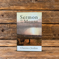 Sermon on the Mount by Clarence Jordan, paperback book standing upright against a rustic wooden background.