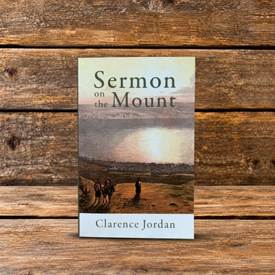Sermon on the Mount by Clarence Jordan, paperback book standing upright against a rustic wooden background.